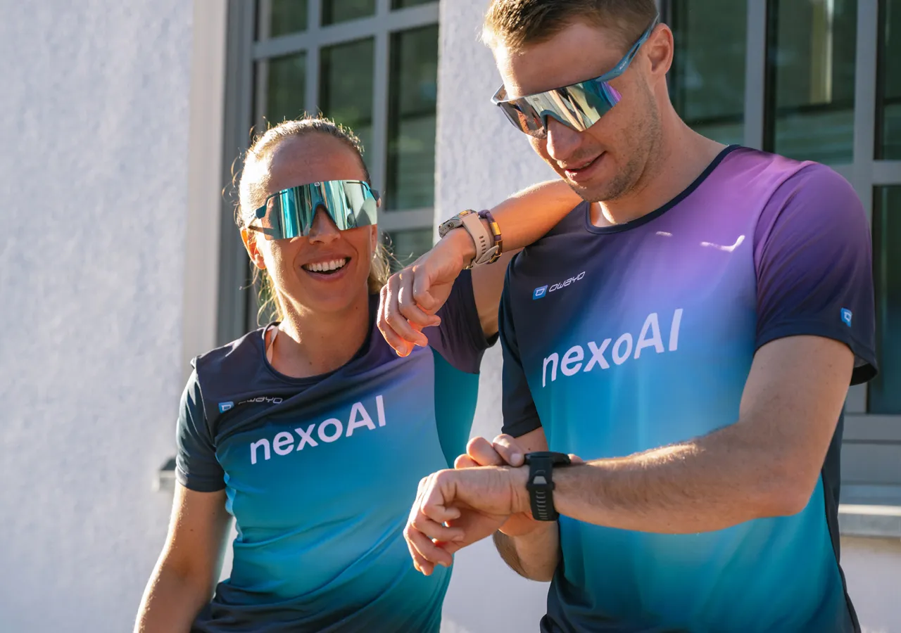 Due persone vestite in modo sportivo con magliette personalizzate si divertono mentre guardano i loro orologi.