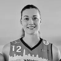 Una donna con una maglia sportiva con il numero 12 e un disegno di skyline cittadino.