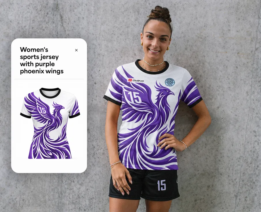Una donna indossa una maglietta sportiva bianca con un design di fenice viola e il numero 15, mentre è in piedi davanti a un muro grigio.